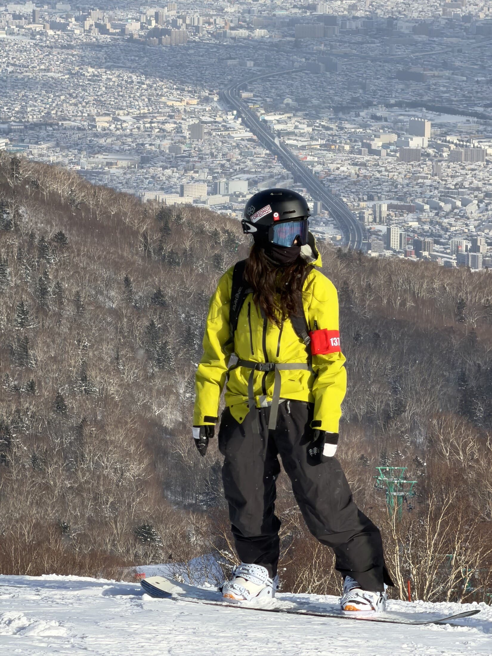 Snowboarder above the Sapporo panorama at Teine