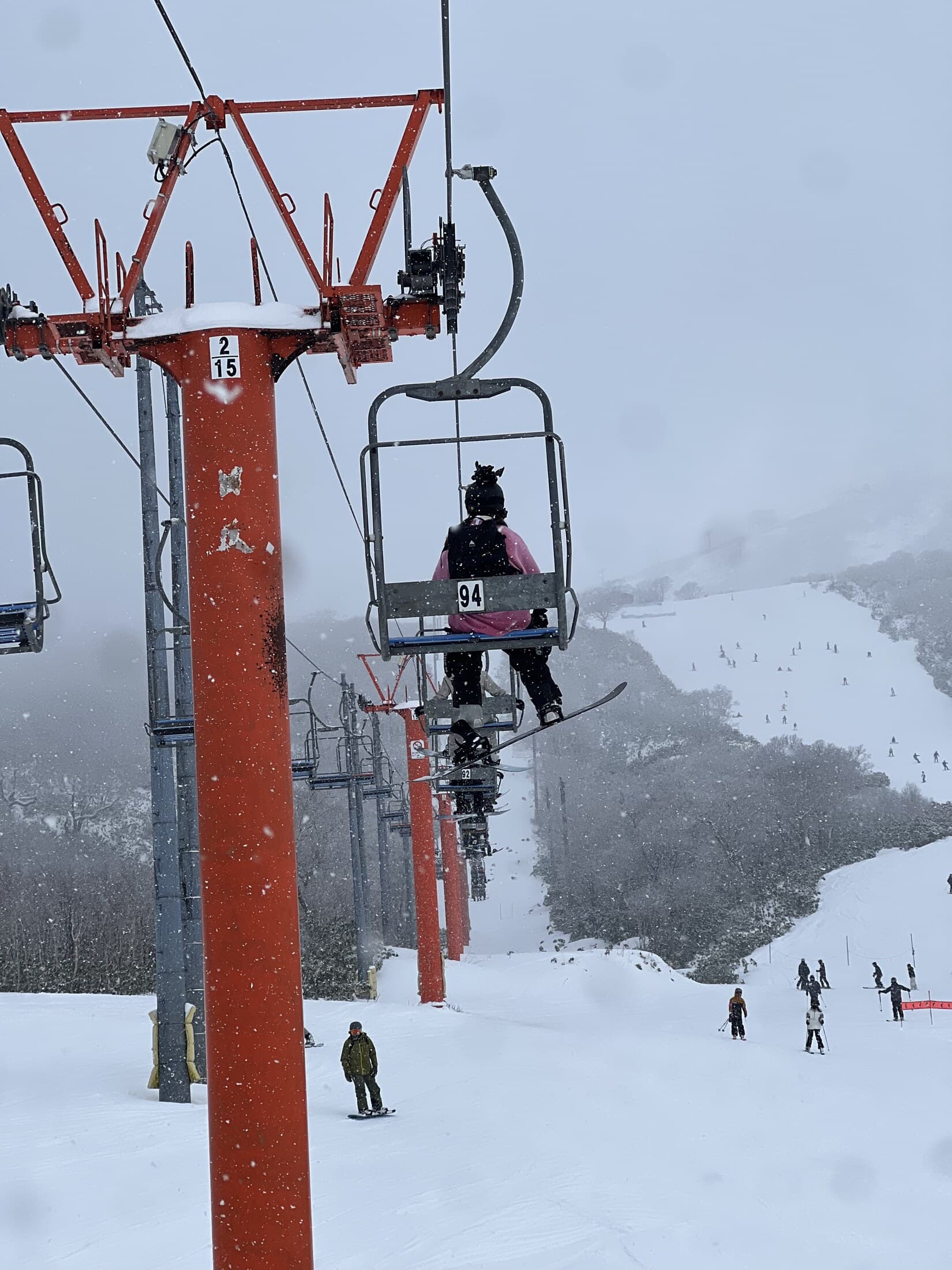 Red chairlift above snow-covered slopes