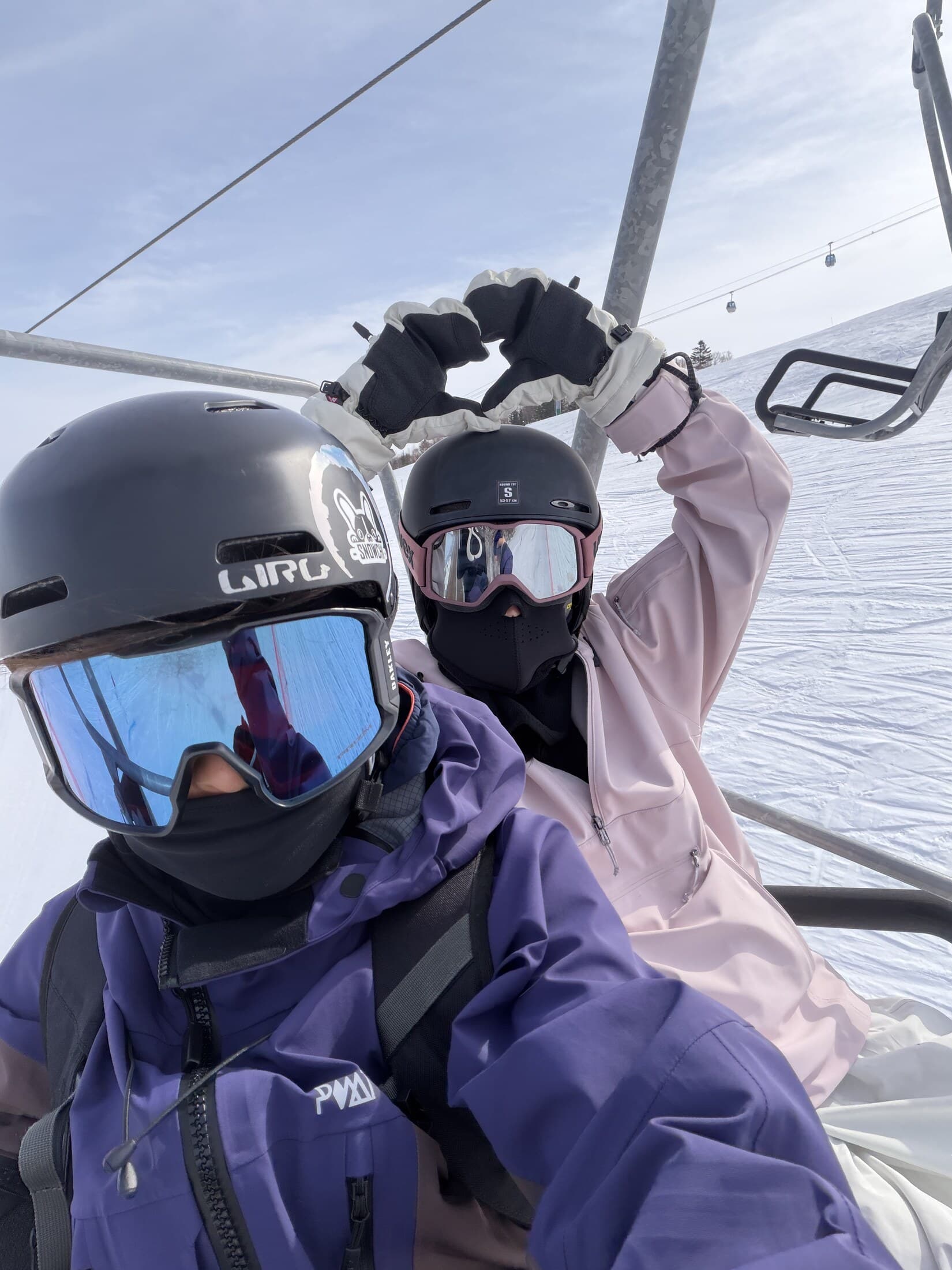 Guests making a heart gesture on a chairlift