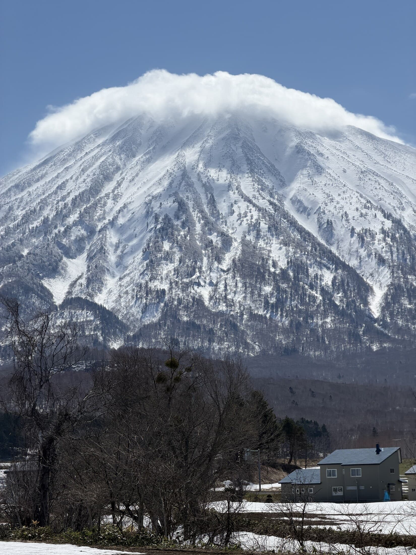 Snow-covered Mount Yotei beneath spring clouds